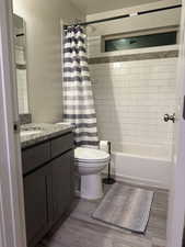 Full bathroom featuring vanity, dark wood-style flooring, and shower / bathtub combination with curtain