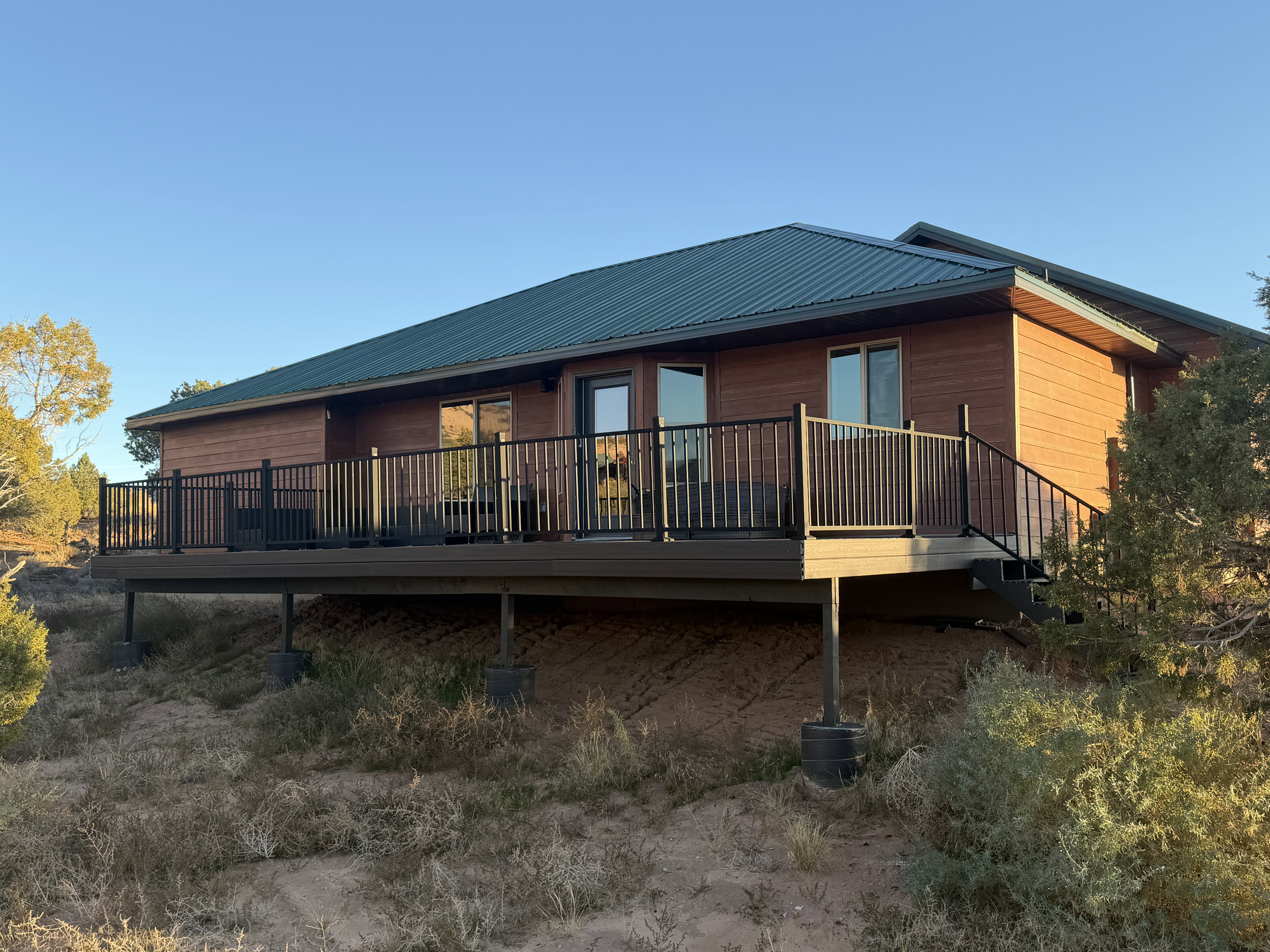 Back of property featuring a metal roof and a deck
