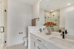 Full bathroom with double vanity, a shower stall, light tile patterned flooring, and recessed lighting