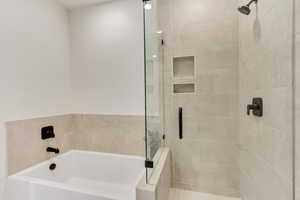 Bathroom featuring a garden tub and a shower stall