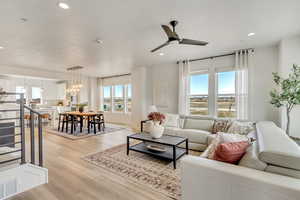 Living room with light wood-style floors, ceiling fan, recessed lighting, a textured ceiling, and a chandelier