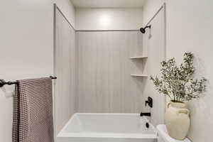 Bathroom featuring toilet and shower / bath combination