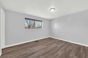 Spare room featuring wood finished floors and baseboards