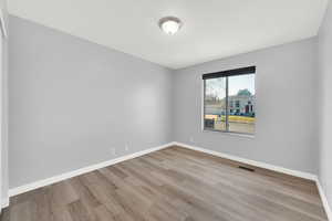 Unfurnished room with light wood-type flooring and baseboards