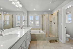Full bath with a bath, double vanity, light tile patterned floors, a stall shower, and recessed lighting