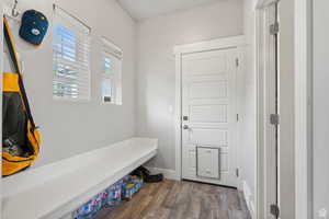 Mudroom featuring dark wood-style floors and baseboards