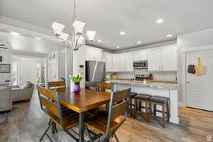 Dining space featuring recessed lighting, light wood-style floors, and a chandelier