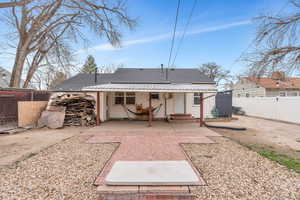 Rear view of house featuring roof with shingles and a patio area