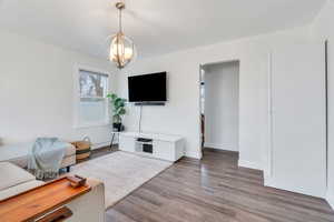 Living area with wood finished floors and a chandelier