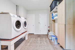 Laundry room featuring unfinished concrete floors and washing machine and dryer