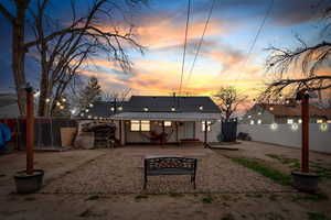Back of house at dusk with a patio area