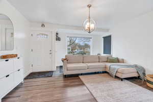 Living room with light wood-style flooring and a chandelier