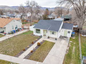 View of front of property featuring roof with shingles, driveway, a mountain view, and a residential view