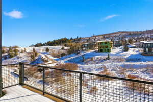 Snow covered deck featuring a balcony
