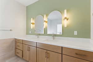 Full bathroom with double vanity, light tile patterned floors, and tile walls