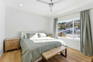 Bedroom featuring light wood finished floors, ceiling fan, and recessed lighting