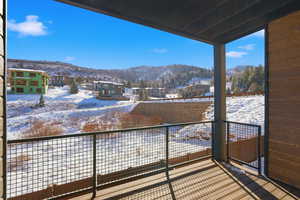 Snow covered back of property with a mountain view