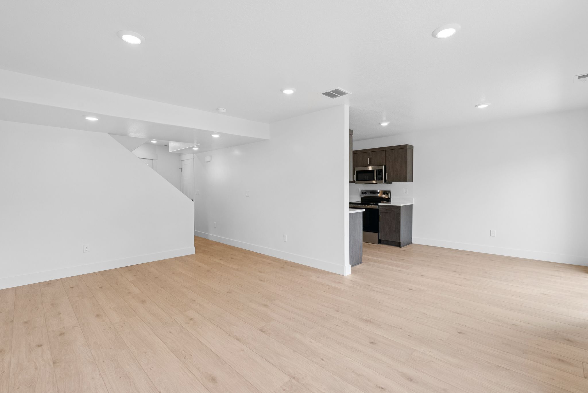Unfurnished living room with light wood-type flooring and recessed lighting
