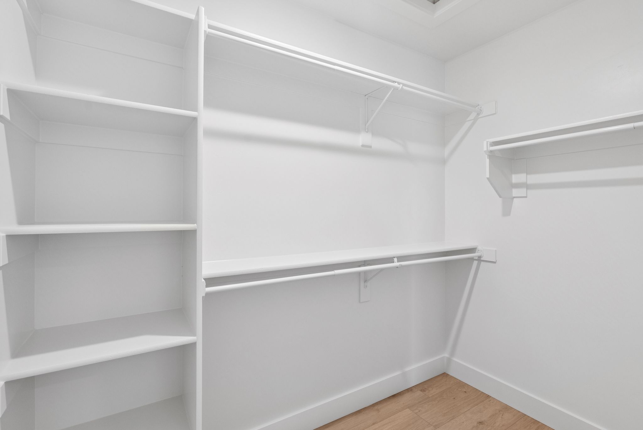 Walk in closet with light wood-style flooring