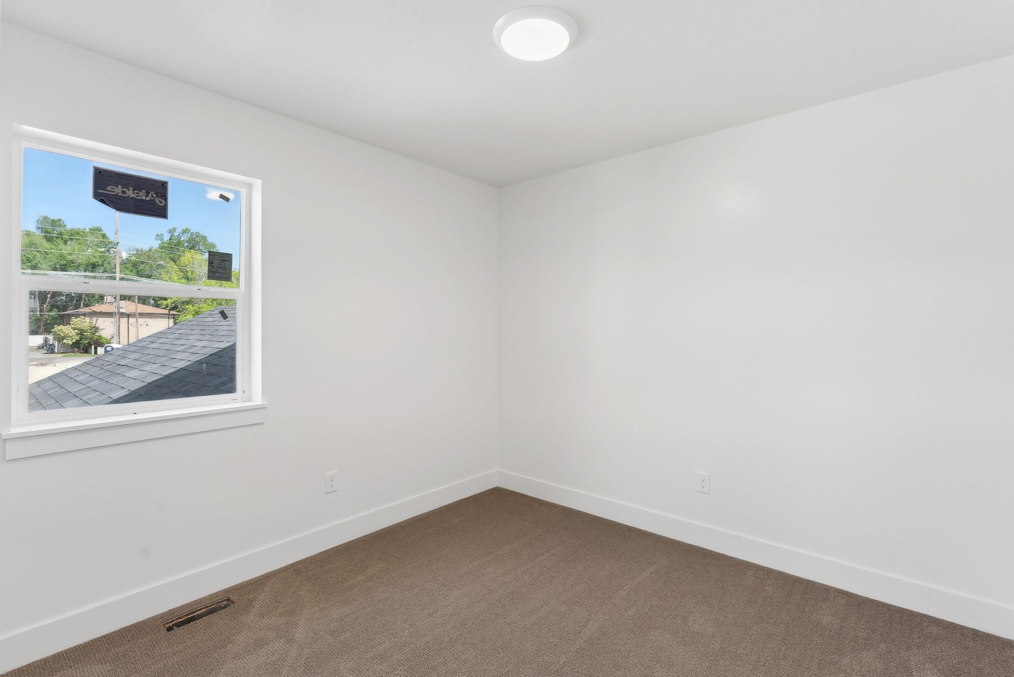 Carpeted spare room featuring baseboards