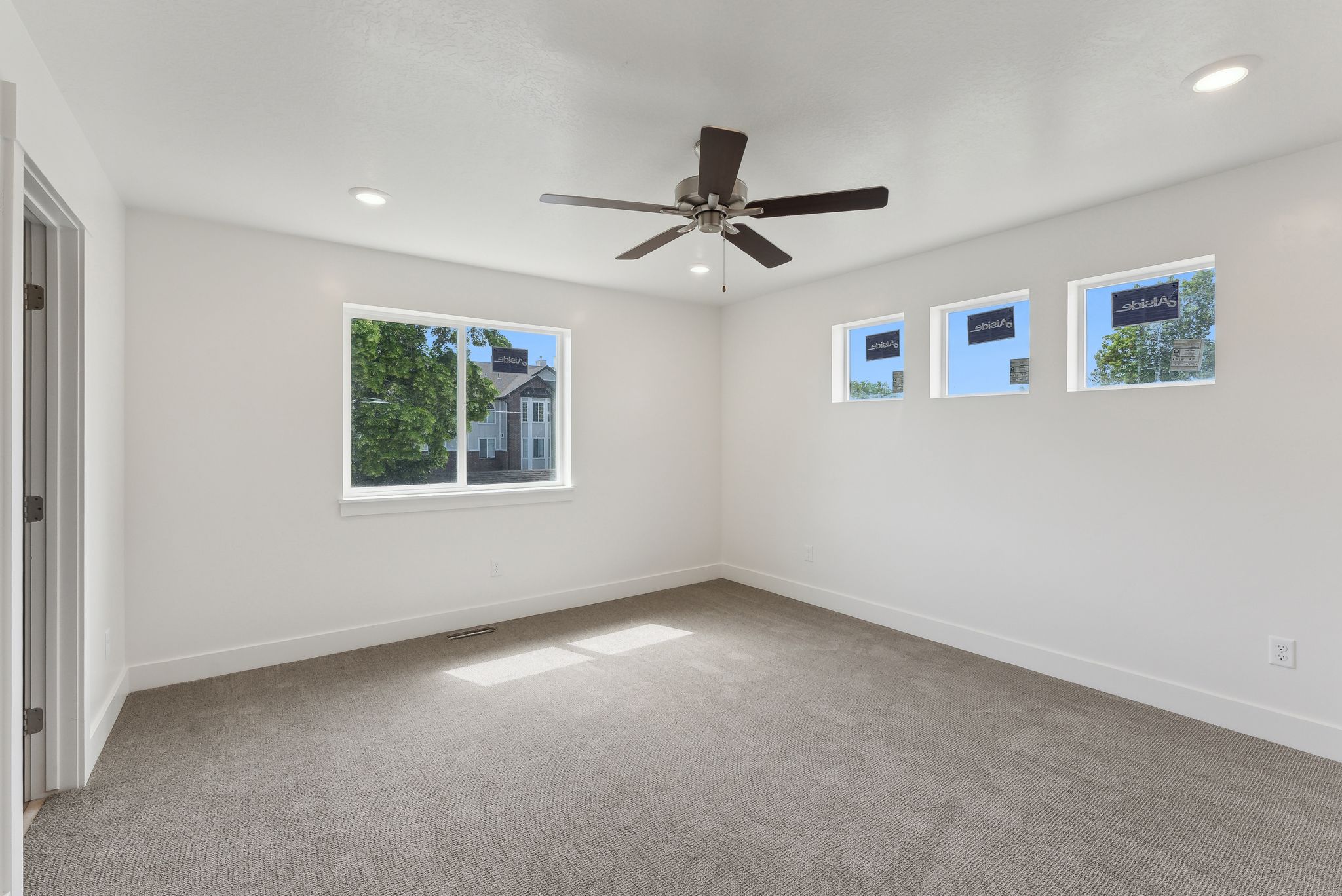 Empty room with light carpet, ceiling fan, and recessed lighting