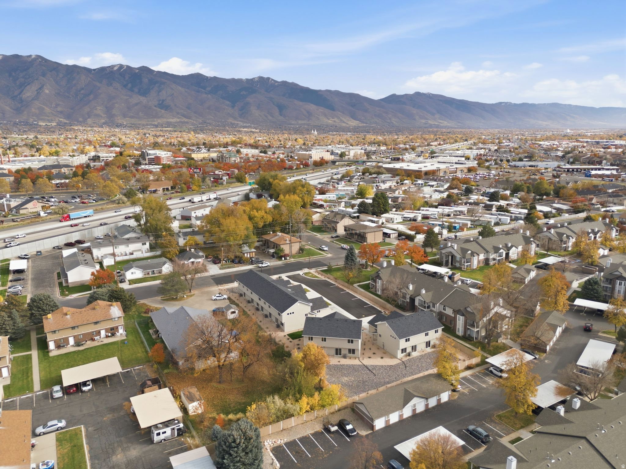 Aerial view of property and surrounding area featuring nearby suburban area and mountains
