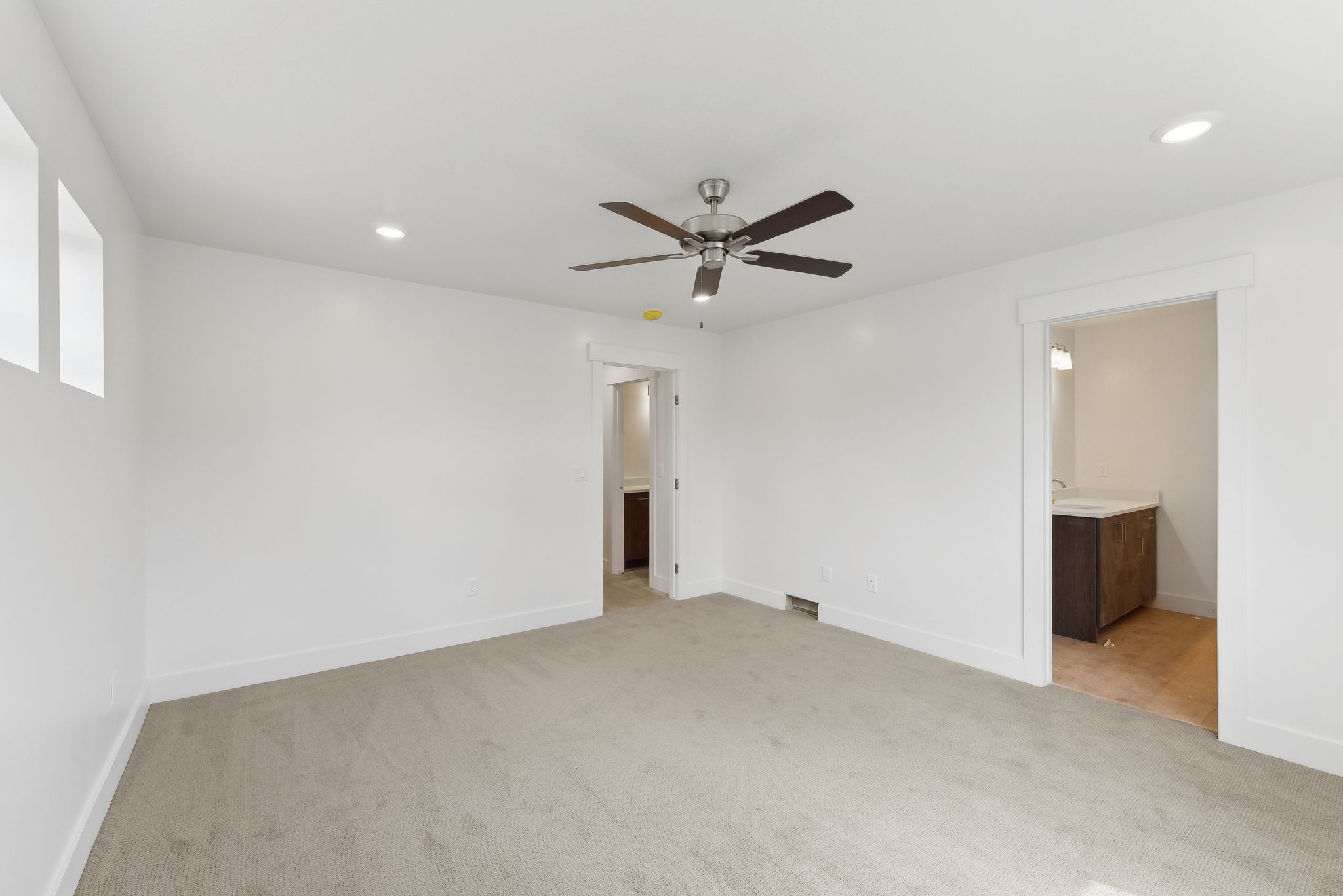 Unfurnished bedroom featuring light carpet, recessed lighting, ceiling fan, and connected bathroom