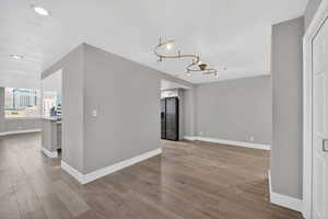 Unfurnished dining area with light wood-style flooring and baseboards