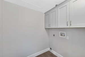 Laundry room featuring hookup for an electric dryer, cabinet space, hookup for a washing machine, and dark wood-style flooring