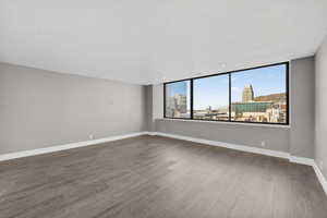 Empty room with a view of city and dark wood-style flooring