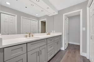 Full bath featuring a closet, double vanity, dark wood-style floors, and recessed lighting