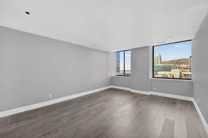Unfurnished room with wood finished floors and a city view