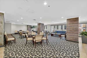 Dining space with light tile patterned floors, recessed lighting, plenty of natural light, and crown molding