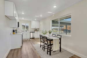 Kitchen featuring light countertops, white cabinets, light wood-style flooring, stainless steel appliances, and recessed lighting