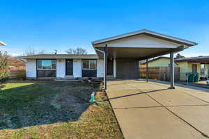 View of front of home with concrete driveway, brick siding, and a carport