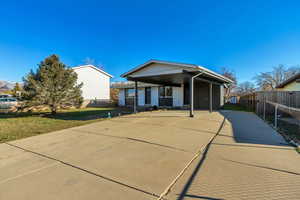 View of front facade featuring concrete driveway and a carport