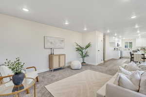 Living room with light colored carpet and recessed lighting