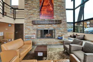 Living room with a towering ceiling and a stone fireplace