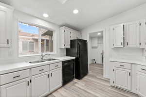 Kitchen featuring white cabinets, light countertops, dishwasher, light wood-type flooring, and recessed lighting