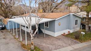 View of front of house featuring driveway, a carport, and a patio area