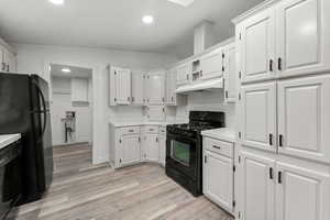 Kitchen featuring black appliances, light countertops, white cabinetry, recessed lighting, and light wood-style floors