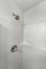Bathroom view of a shower and a textured ceiling