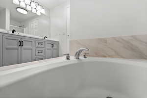 Full bathroom featuring double vanity and a bath