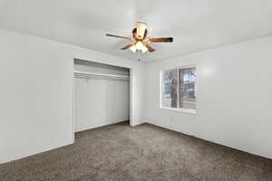 Unfurnished bedroom featuring carpet, a closet, and ceiling fan