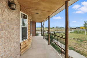 Porch featuring a view of countryside and a yard