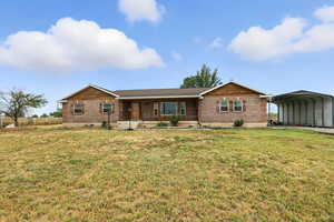 Single story home with a detached carport, a porch, brick siding, and crawl space