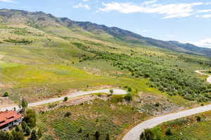 Expansive mountain landscape featuring varied terrain and a paved winding road