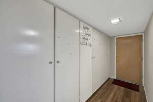 Hall with a textured ceiling and dark wood-style floors
