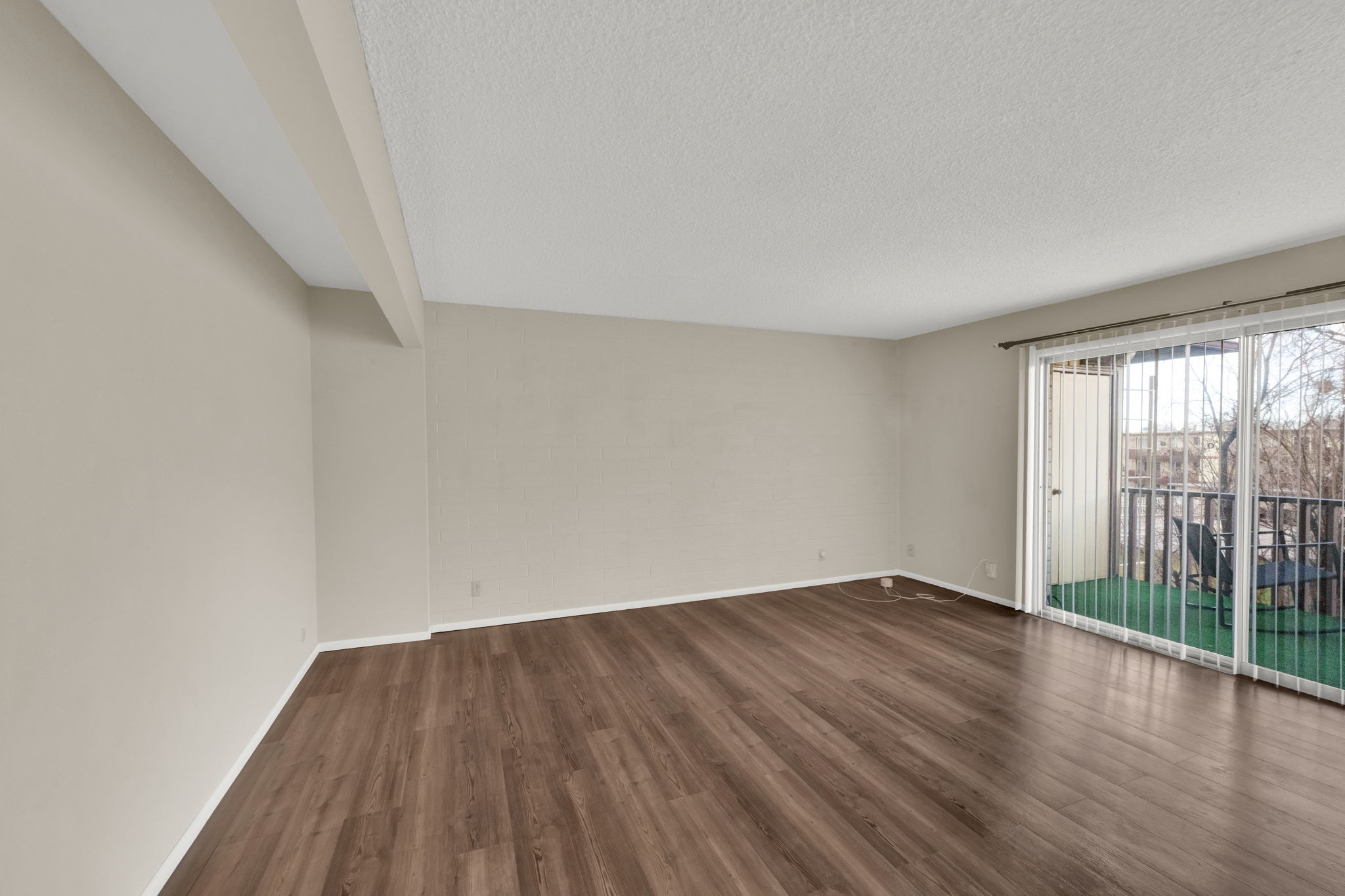 Spare room featuring a textured ceiling and dark wood-style flooring