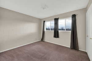 Carpeted empty room with baseboards